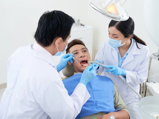 Male patient undergoing regular dental check-up at clinic.